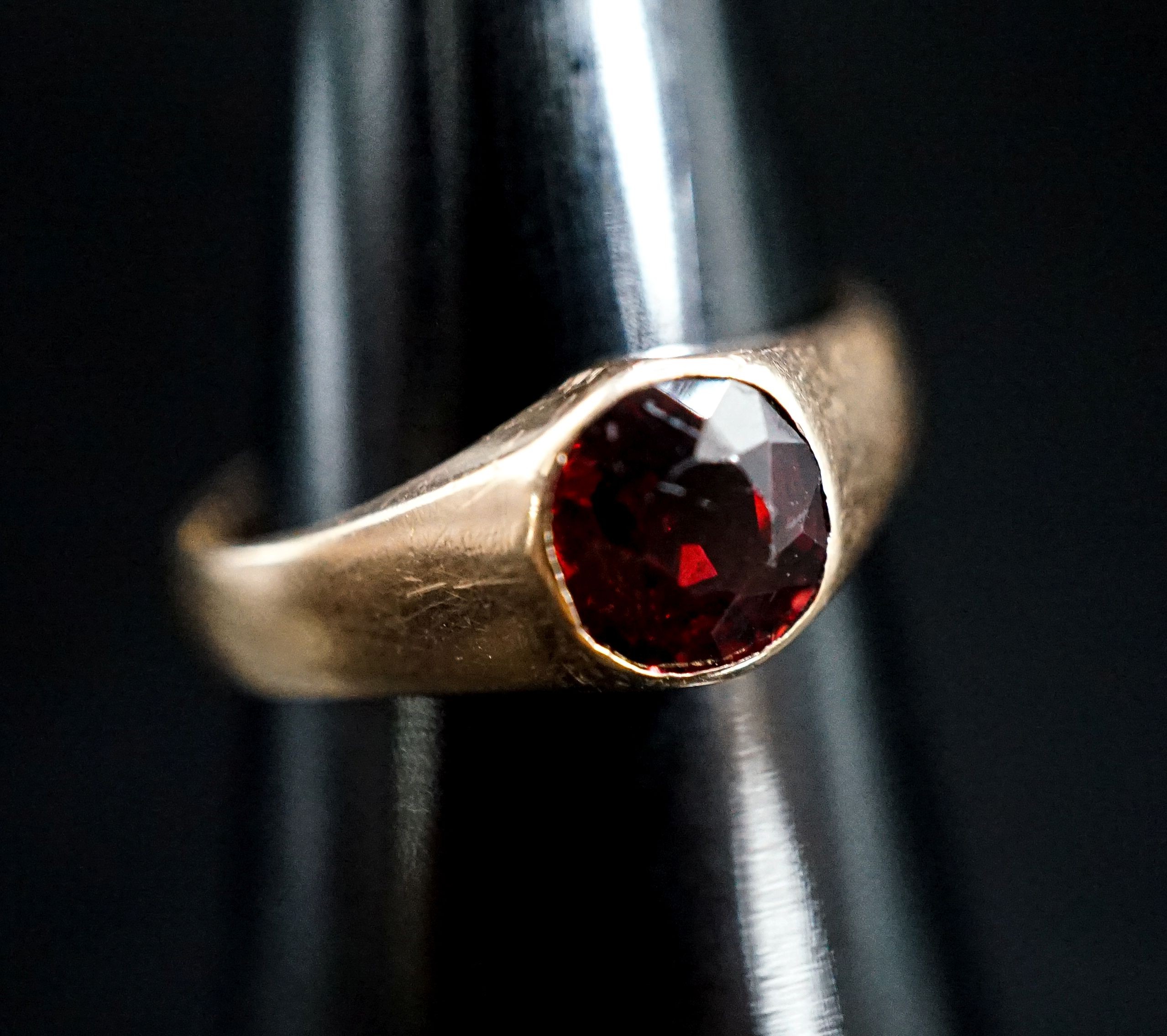 A yellow metal and garnet set ring, size N, gross 4.5 grams.